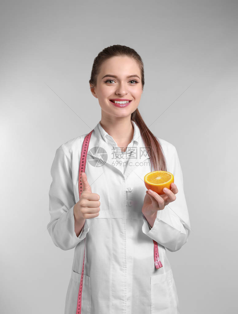 女营养学家的肖像橙色在光背图片