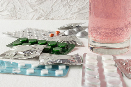 不同类型的药丸药片包装中的封闭药丸在一杯水中图片