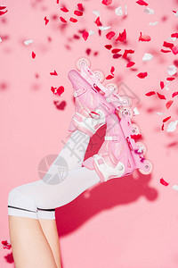 粉红色玫瑰花瓣附近穿长袜和滚背景图片