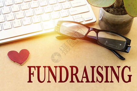 筹款资金本援助建议概念白色键盘和眼镜盆背景图片