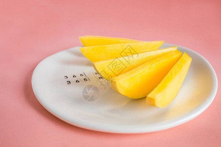 白盘上的芒果水和芒果切片热带水果概图片