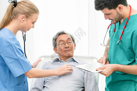 医生团队照顾躺在医院病房床上的老年男病人医疗保健人员图片