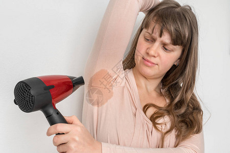 手毛底下有汗水的女人用烘发机图片