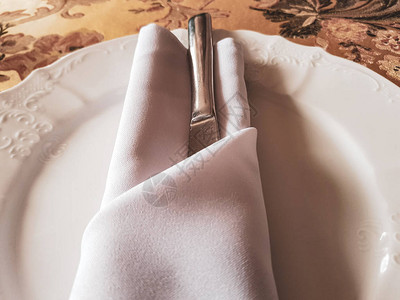 餐桌上的白色彩陶盘和棉餐巾图片