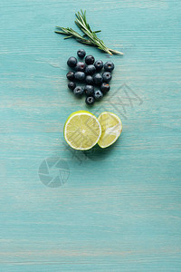 蓝色纹质表面上切柠檬蓝莓和迷迭图片
