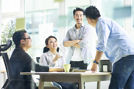 一组四位快乐的年轻亚洲人公司员工团队会议在办公室讨论业务图片