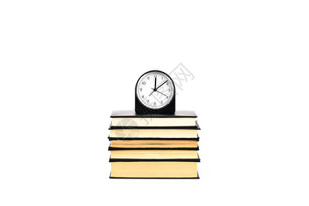 时钟和一摞书被白色隔离图片