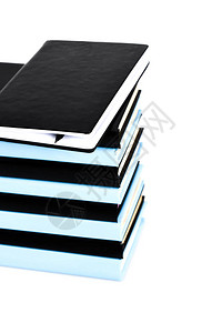 一堆黑色和蓝色的书被白色隔离图片