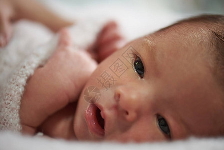 新生婴儿睁开眼睛的特写肖像图片
