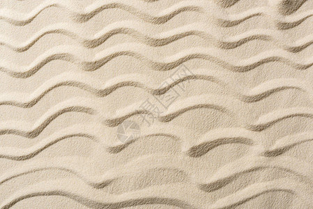 带沙子和平滑波浪的纹理背景的顶视图背景图片