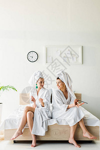 穿着浴袍和首饰头戴毛巾的时装微笑着容的女人们带着指甲图片