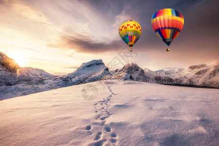 热空气球在雪山上飞翔日出图片