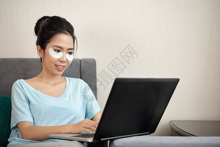 富有魅力的亚洲女在笔记本电脑上工作图片
