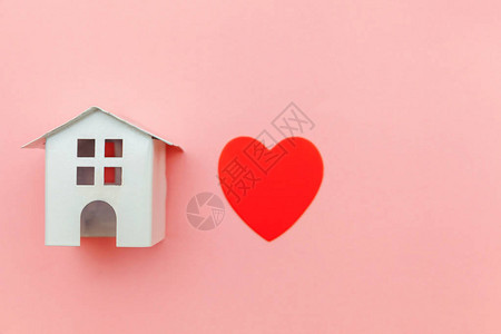 红色心脏孤立在粉红糊涂色彩多的潮流背景上抵押财产保险梦想着家庭概念平面翻版空间背景图片
