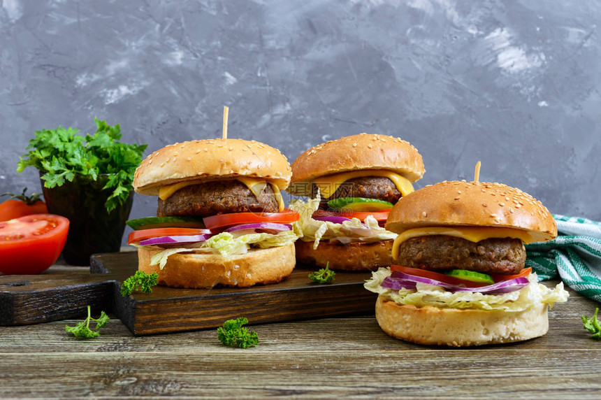汉堡加多汁的小菜新鲜蔬菜脆面包和木制桌上的芝麻种图片