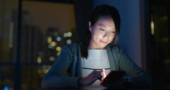 女人晚上看智能手机图片