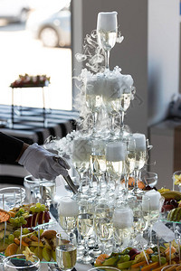 干冰冒烟的香槟塔桌子上的水果图片
