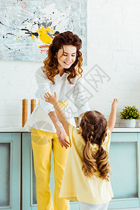 幸福的母亲伸手在厨房图片