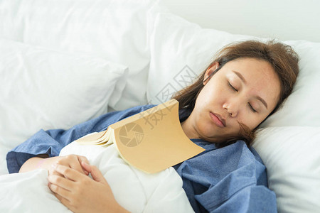 亚洲美女在睡觉时看书人书嗜睡导致睡眠充足睡眠的概图片