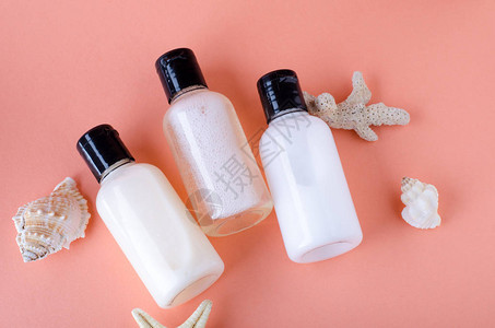 背景上的化妆品瓶与活珊瑚的颜色洗发水护发素和润肤露瓶图片