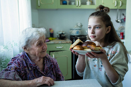 一位老妇人给她的孙女吃早餐图片