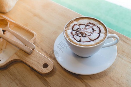 热咖啡与泡沫牛奶艺术黑杯咖啡下午休息时喝热咖啡咖啡杯木桌上的摩卡咖啡茶歇背景图片