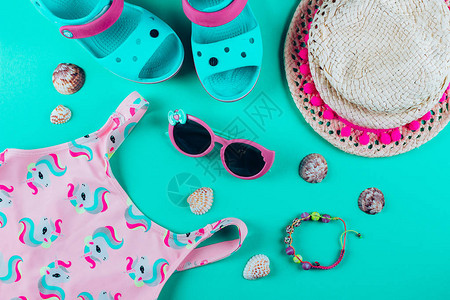 夏季孩子的假期概念泳装夏季凉鞋帽子太阳镜手镯贝壳平躺上方明亮图片