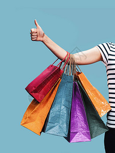 商业和购物季节快乐的年轻女子拿着纸袋图片