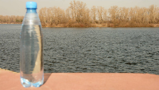 在河的背景的一瓶水背景图片