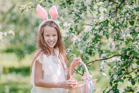 小女孩在复活节的盛开的苹果树花园里满篮子鸡图片