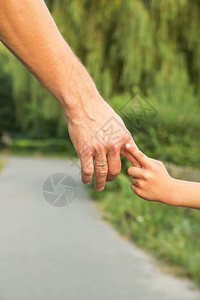 父母牵着孩子的手有着幸福的背景图片