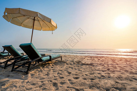 阳光雨伞和椅子在热带图片
