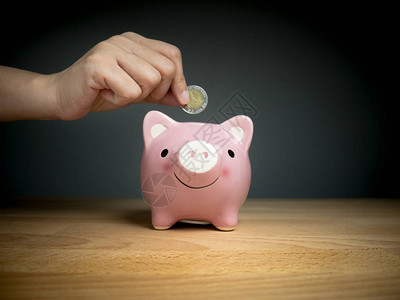 将硬币添加到小猪银行的储蓄金币时间图片