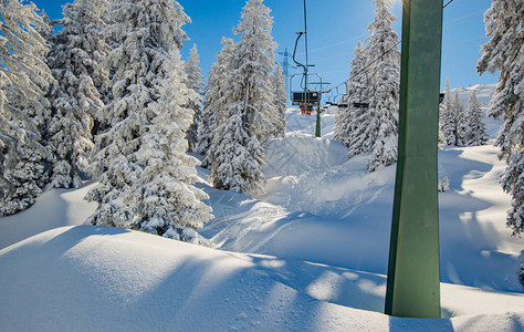 阳光下雪山上索道的景色图片