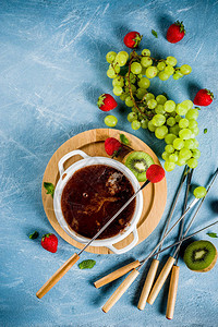 草莓葡萄和猕猴桃的甜果味巧克力火锅甜点图片