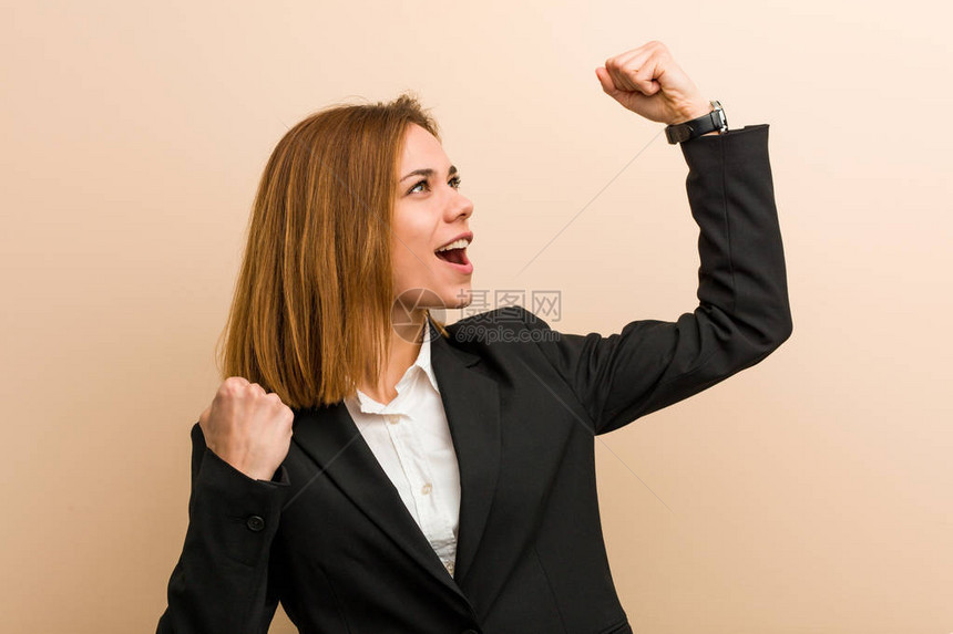 年轻的天主教女商人在胜利后举起拳头图片