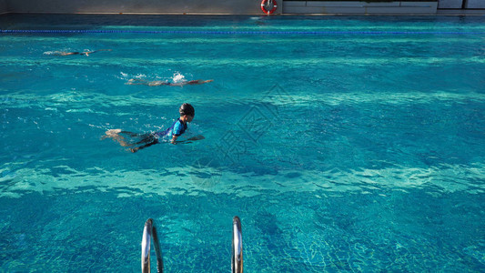 亚洲男孩在比赛中与左边温暖的阳光游泳选定焦点宽度比背景图片