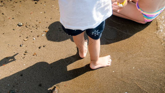 海边沙滩上孩子脚的特写图片