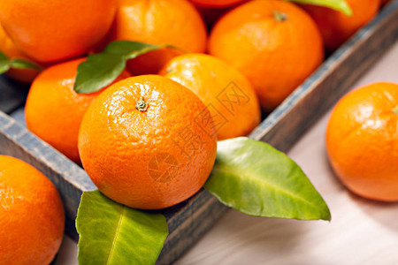 含叶子的新鲜橙子水果木制桌上有叶子图片