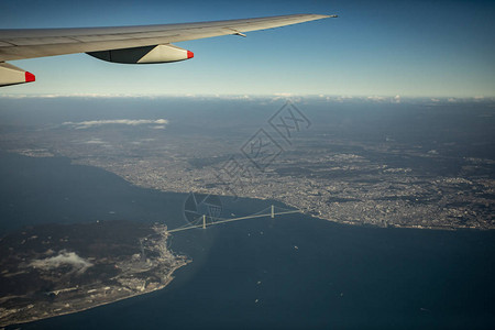 从AkashiKaikyo大桥上空的飞机图片
