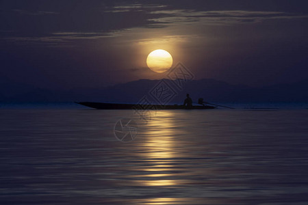 在湖边船上的休游渔民蓝时日落图片