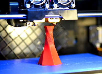 3D打印机在蓝色和特写的基础上打印孤立的体积三角形物体红色现代背景图片