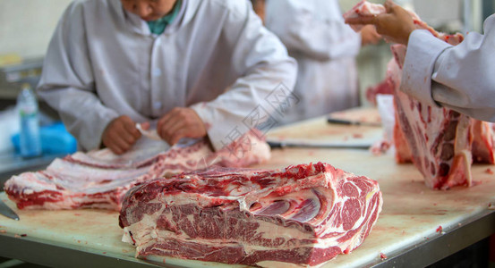 屠夫在肉店切生牛肉背景图片