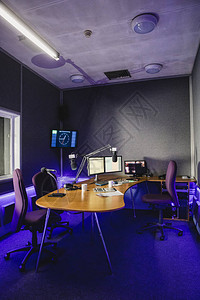 对讲控制面板对一个无线电台演播室内部一个大型办公桌在会议室中间的一张照片进行前视背景