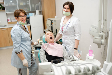 牙医与护士在牙科诊所对老年男患者进行牙科治疗老年人的牙齿护理牙科医图片