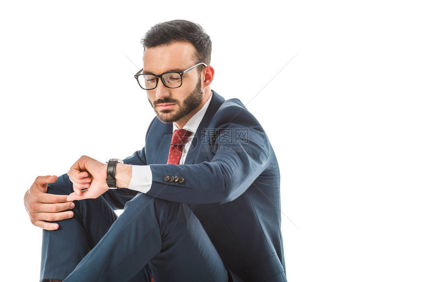 身戴眼镜的严肃商人看着手表坐着与图片