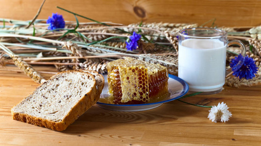蜂蜜在梳子里面包和牛奶放图片