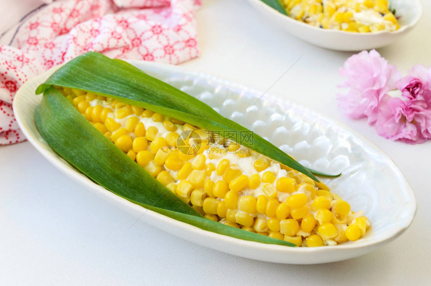 以玉米的形式为假日餐桌提供美丽的沙拉浅色背景下盘子里的玉米李子奶图片