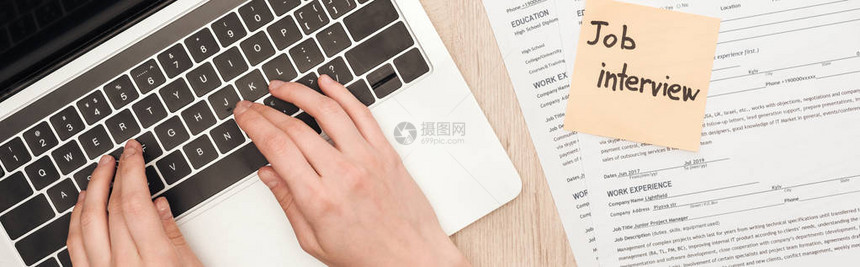 笔记本键盘上的征聘人员打字在履历模板和贴有面试信函的粘贴注图片