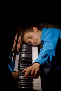 坐在钢琴前的年轻人图片